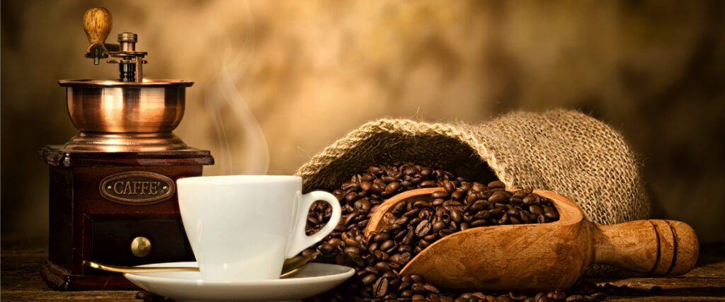 A cup of coffee placed with a bag of coffee beans