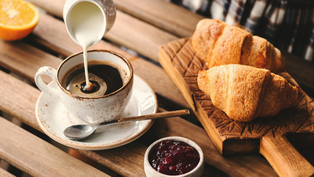 Cup of coffee serving with croissant