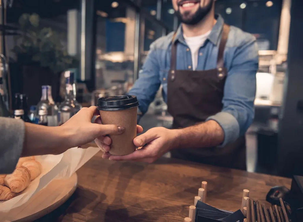 customer handing coffee cup