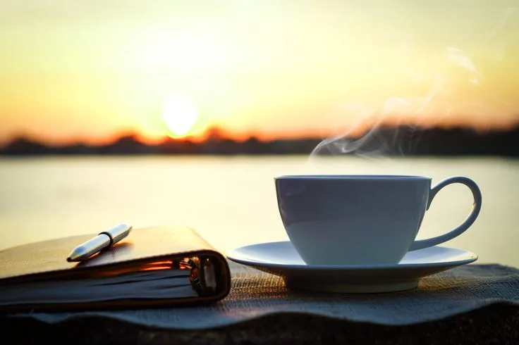 a morning coffee cup with the sun rise view